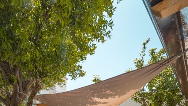 A hot tub in a backyard with wooden walls, a tree, and a yellow fence. - b&b Domus Vesuvia (Torre Annunziata)