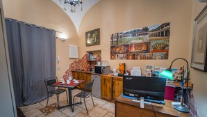 A compact kitchen with a dining area, a small refrigerator, a microwave, and a sink. - b&b Domus Vesuvia (Torre Annunziata)