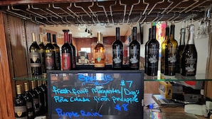 A bar area with a chalkboard menu listing specials like fresh fruit Margaritas, Dog's Breath Pineapple, and Purple Rain Bob Marley. - Delta Queen Lodge Bar Restaurant (Isleton)