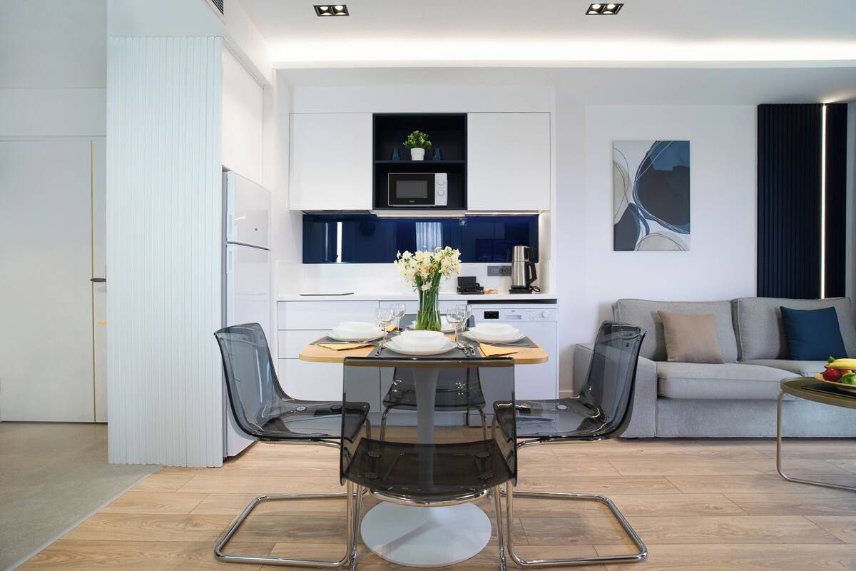 A modern living space with a dining area, kitchen, and seating area.
