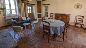 A rustic dining area with a wooden table, chairs, and a cabinet.