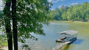 A wooden pier extending into a calm river, surrounded by lush greenery and trees. - Thomas Mill Creek Lakefront Property  (Abbeville)