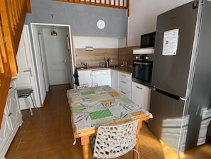 A compact kitchen with a refrigerator, microwave, and a clock on the wall. - Charming air-conditioned pavilion with pool, near beach (Argelès-sur-Mer)