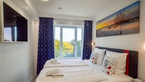 Een hotelkamer met een groot bed, een televisie en een schilderij.