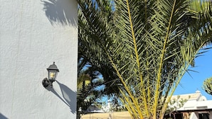 A white building with a palm tree in front. - Relaxing Private Villa a Short Walk From Seafront (Playa Blanca)