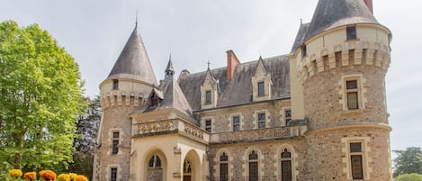 Un castillo de piedra histórico con múltiples torres y ventanas de arco.