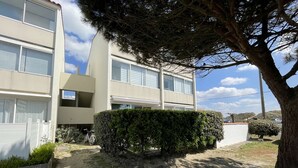 Un bâtiment moderne à deux étages, doté d’un toit plat, de grandes fenêtres et d’une haie bien entretenue à l’avant.