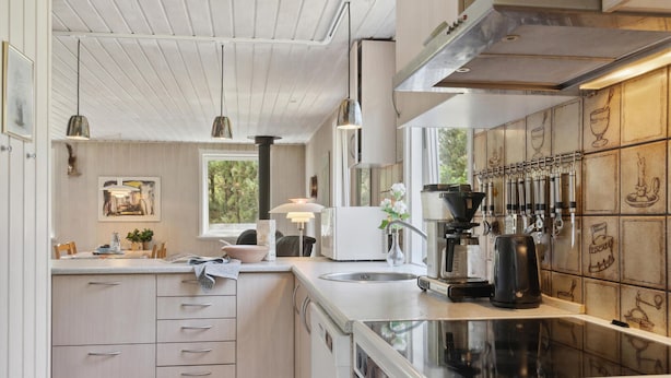 A modern kitchen with a central island, stainless steel appliances, and a window providing natural light.