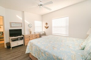 A bedroom with a bed, dresser, television, and decorative items. - Ocean Village Club Q22 (St. Augustine)