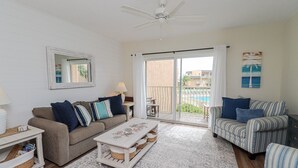 A living room with a sofa, armchairs, a coffee table, and a ceiling fan. - Enjoy the Sunrise and the Sunset from your very own Balcony! (St. Augustine)