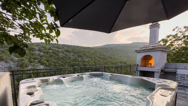 Ein Whirlpool mit Blick auf eine gebirgige Landschaft.