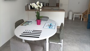 Une cuisine moderne avec des armoires blanches, une hotte en acier inoxydable et un plan de travail en bois.