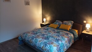 Une chambre à coucher avec un lit, deux tables de chevet et un luminaire suspendu.