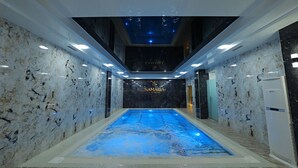 An indoor swimming pool with a marble wall and ceiling, surrounded by a corridor with a modern design. - Samaria Hotel and Spa (Samarkand)