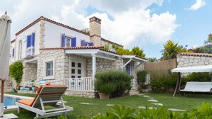 A stone house with a pool, outdoor seating, and a garden. - PANDA ALAÇATI OTEL (Cesme)