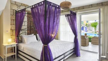 A bed with a canopy, a bedside table, and a view of an outdoor swimming pool.
