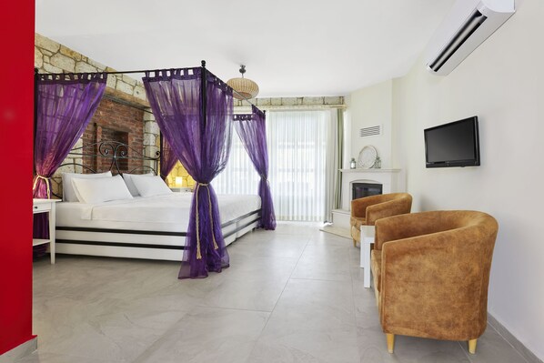 Un dormitorio con cama, dosel morado, paredes blancas, televisor y chimenea.