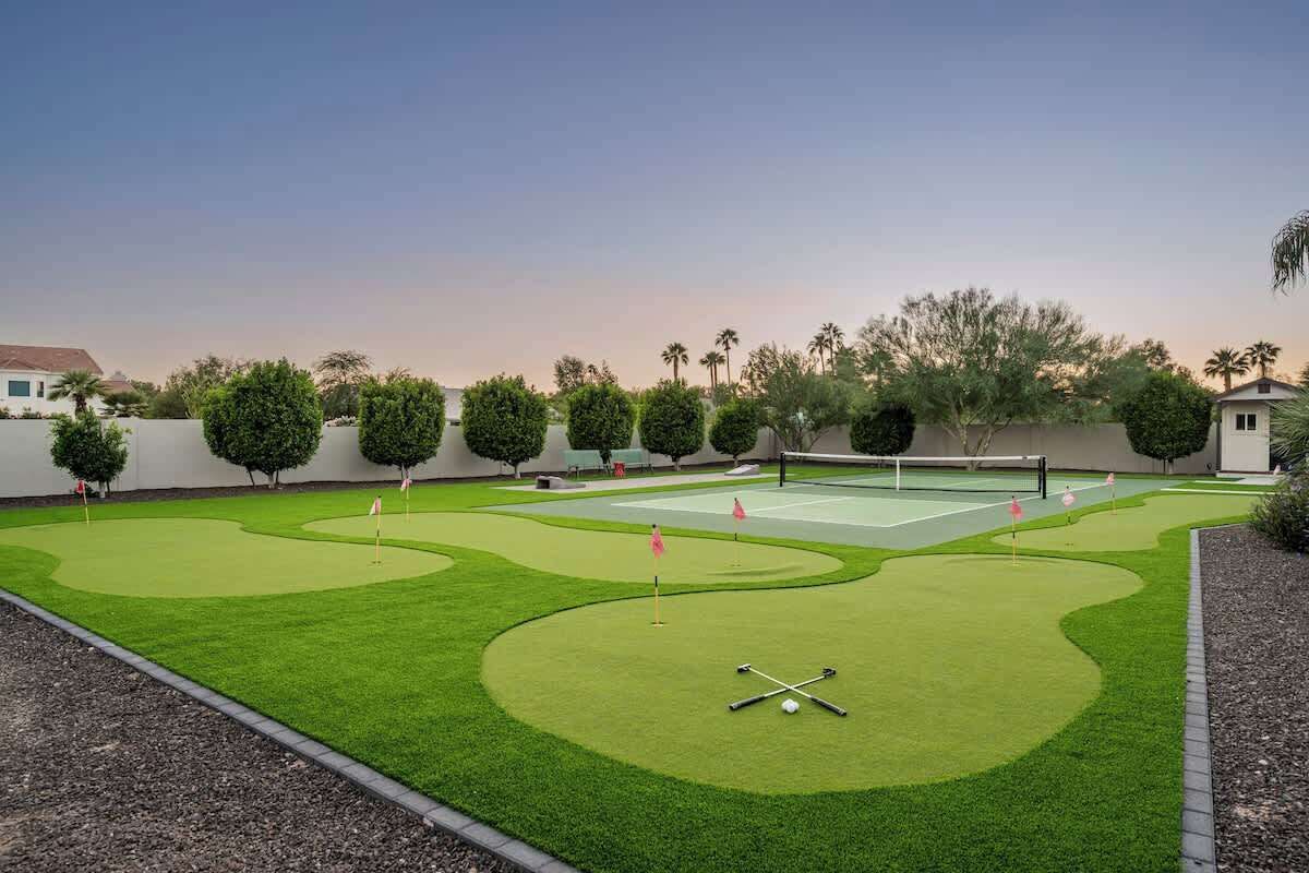 A miniature golf course with a green lawn, sand traps, and a putting area.