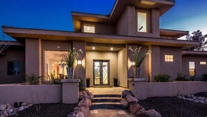 A modern two-story house with a stone pathway leading to the entrance, surrounded by rocks and plants. - Private Mini-Resort w/ Salt water pool & spa- NEW! (Scottsdale)