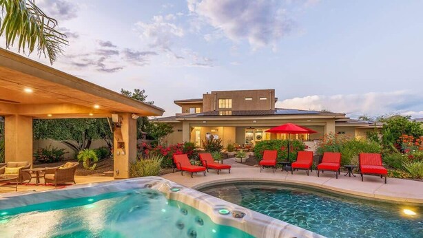 A swimming pool with a hot tub, red lounge chairs, and a covered patio area. - Private Mini-Resort w/ Salt water pool & spa- NEW! (Scottsdale)