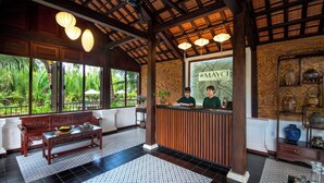 A reception area with a wooden reception desk, a bench, and a patterned floor.
