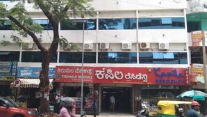 A multi-story building with various shops on the ground floor, including a medical clinic and a pharmacy. - kapila residency (Bengaluru)