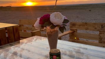 Una mesa con una lata de Laimonfresh y un florero con flores.