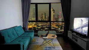 A modern living room with a teal sofa, a coffee table, and a TV on a stand. - "La Gente", The People (rakyat) in Spanish, represents our dedication and passion to serve our guests and meet interesting souls. (Kuala Lumpur)