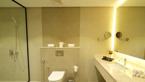 A modern bathroom with a glass shower enclosure, a toilet, a bidet, and a vanity with a mirror. - FARHAN TOWER (Manama)