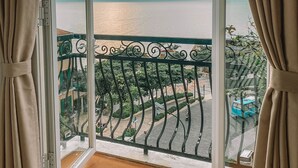 A balcony with a view of the sea and a distant cityscape. - La Palma Hotel & Spa Sunset Town Phu Quoc (Phu Quoc)