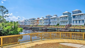 Una zona residenziale sul lungomare con case colorate, passerelle in legno e un cielo azzurro limpido.