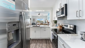 Una cucina moderna con elettrodomestici in acciaio inossidabile, mobili bianchi e forno integrato.