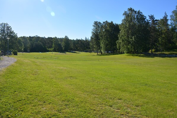 A large, open grassy field with trees in the background. - Hällestrand Semesterby och vandrarhem (Stromstad)