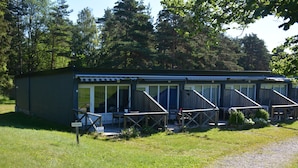 A small, single-story motel with a covered outdoor seating area and a gravel driveway.