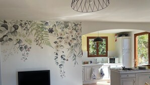 Eine moderne Küche mit weißen Schränken, einer eingebauten Mikrowelle und einem Fenster mit Blick auf Grünflächen.