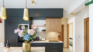 A modern kitchen with dark cabinetry, a central island, and pendant lighting. - Modern Villa with Terrace View, Private Pool & BBQ (Rethymno)