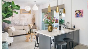 A modern kitchen with a central island, bar stools, pendant lights, and a large potted plant. - Modern Villa with Terrace View, Private Pool & BBQ (Rethymno)