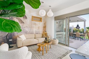A modern living room with a sofa, coffee table, and dining area.