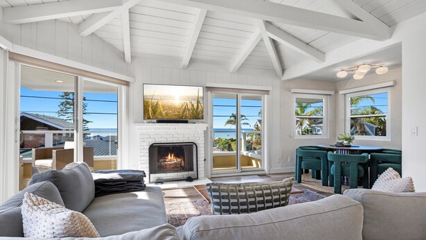 A spacious living room with a fireplace, large windows, and a cozy seating area.