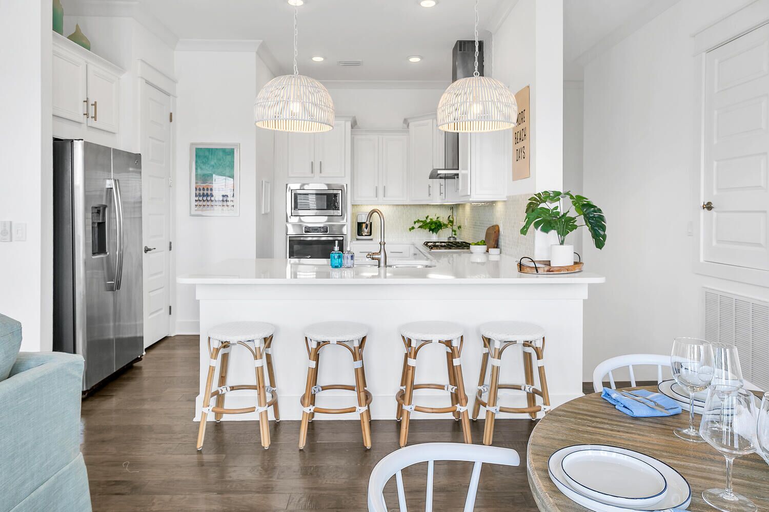 A modern kitchen with white cabinets, stainless steel appliances, and a central island with bar stools.