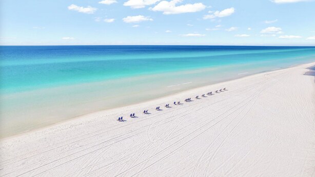 Ein Strand mit blauem Himmel und ruhiger See.