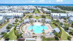 Ein Resort mit einem zentralen Schwimmbad, mehreren Gebäuden und Blick aufs Meer.