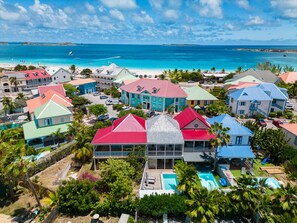 A coastal residential area with colorful houses, a swimming pool, and a view of the ocean. - Sunshine 7 (Collectivity of Saint Martin)