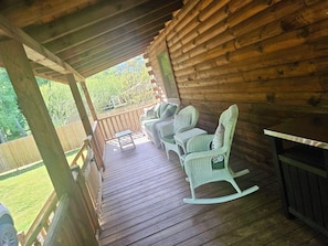 A wooden deck with wicker furniture and a table.