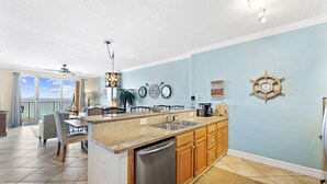 Una cocina con una isla central, armarios de madera y vistas al exterior.