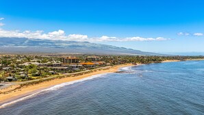 Una località costiera con proprietà fronte mare, una spiaggia e una montagna sullo sfondo.