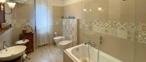 Un baño moderno con una bañera independiente, un tocador con doble lavabo y un inodoro.