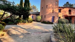 A building with a circular tower, a balcony, and a gravel driveway. - La Tourelle des Ocres by Interhome (Roussillon)