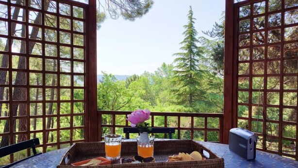 A table with a tray of food and drinks, a flower, and a portable heater. - La Tourelle des Ocres by Interhome (Roussillon)
