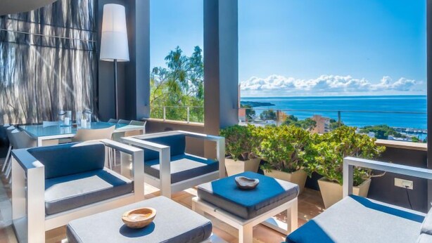 Un área de descanso exterior moderna con asientos y vistas al océano.